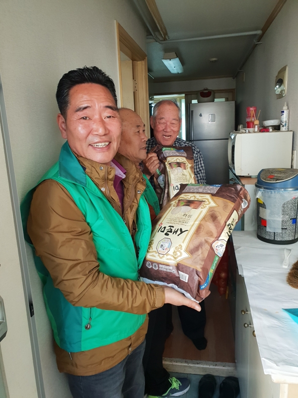 금호1가동 새마을지도자협의회 회원들이 이웃들에게 사랑의 쌀을 전달하는 모습