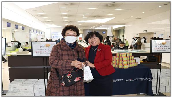 (오른쪽) 한국건강관리협회 동부지부 이은희 본부장 이 협회를 방문한 고객에게 부럼을 나누어 드리고 있다