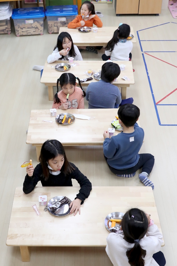 우리동네키움센터 성동1호점 ‘스위첸 아이꿈누리터‘에서 마주보지 않고 지그재그로 떨어져 앉아 간식을 먹고 있는 아이들
