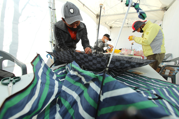 24일 성동구 살곶이 체육공원에서 열린 ‘제 2회 성동 생활밀착의 날’ 수리마당에서 성동구 관계자들이 우산을 수리하고 있다.