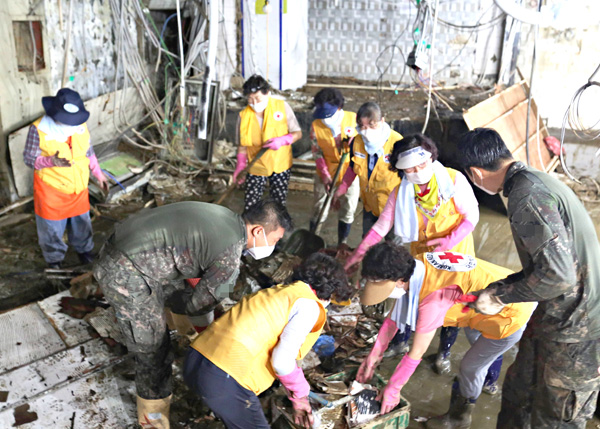 서울 사당동 호우 침수피해 소상공인을 위한 현장 복구 활동을 펼치는 적십자 봉사원과 국군 장병.